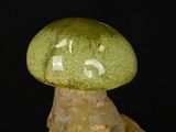a green glass mushroom sitting on top of a rock