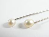 une paire de boucles d'oreilles en perles blanches sur fond blanc