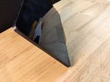 a laptop computer sitting on a table with a wooden surface