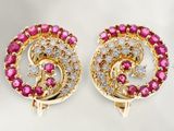 une paire de boucles d'oreilles en diamants roses et blancs posées sur un fond blanc