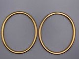 une paire de boucles d'oreilles créoles en or sur fond gris