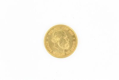 gros plan d'une pièce d'or sur une surface blanche