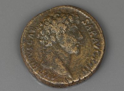 Gros plan sur une pièce de monnaie posée sur une table, sur fond gris
