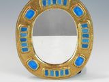 an image of a gold and blue ring shaped mirror on a white surface