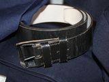 a black belt with a white buckle on a blue jacket