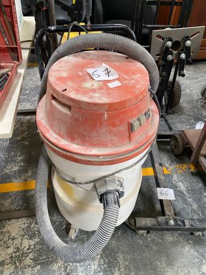 un aspirateur rouge et blanc posé par terre