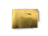 an image of a piece of gold metal on a white surface