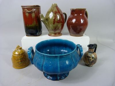 cinq vases différents exposés sur une étagère blanche