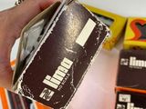 a person holding a wallet in front of a pile of other items