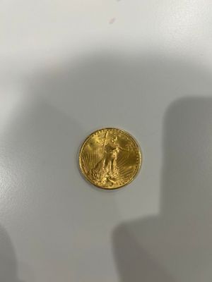 a close up of a gold coin sitting on top of a white surface