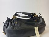 a black purse with a tag on it sitting on a white surface