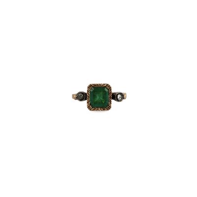 a close up of a ring with a green stone on it