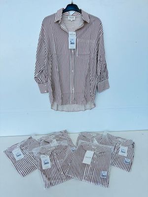a white and brown striped shirt sitting on top of a white table