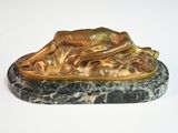 bronze sculpture of a dog resting on a marble base