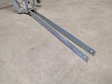 a pair of metal brackets on the ground in a garage