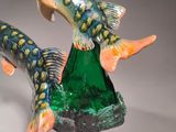 two figurines of fish that are on a table