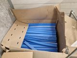 une boîte en carton contenant un tas de bâtonnets en plastique bleus