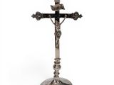 a silver cross on a stand with a crown on top