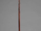 an old wooden pole with a metal handle on a gray background