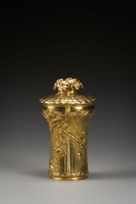 une image représentant un vase en or surmonté d'un oiseau