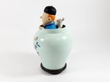 a figurine of a man sitting in a vase
