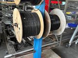 deux bobines de fils noirs et blancs posées sur une palette dans un entrepôt