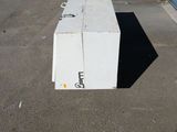 a white box sitting in the middle of a parking lot