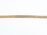 a wooden stick with a cross on it on a white surface