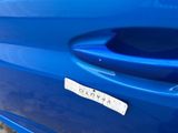 a close up of a blue car with a sticker on it