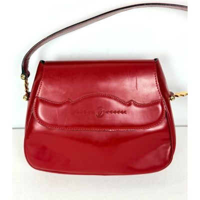 sac à main en cuir rouge avec une poignée et une bandoulière, sur fond blanc