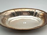 an antique silver plate with handles and handles on a table