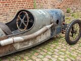 an old car sitting on the side of a brick road