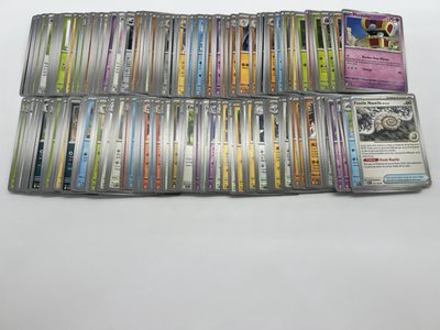 a pile of pokemon trading cards sitting on top of a table