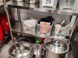 many pots and pans on the shelf in the kitchen