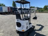 a small white machine parked in a parking lot next to a truck