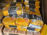 de nombreux sacs de ciment posés sur des palettes dans le garage