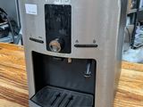 a coffee maker sitting on a wooden table in a kitchen
