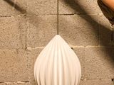 a woman that is standing next to a wall with a lamp