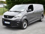 une petite camionnette grise garée sur un parking