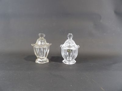 une paire de salières et poivrières en verre transparent posées sur une table