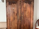a wooden armoire in the corner of a room
