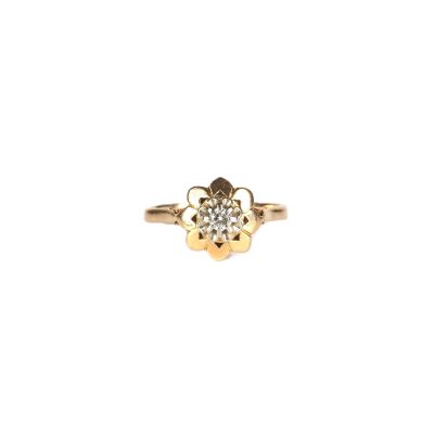 gros plan d'une bague en or avec un diamant au centre