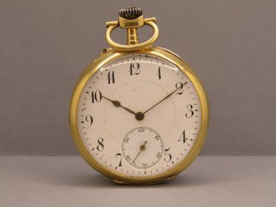 une montre de poche en or posée sur une table