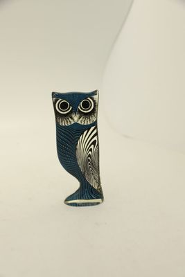 a small blue owl figurine sitting on a white surface