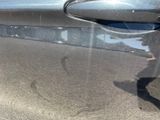 a reflection of a person on the side of a car door