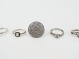 a group of five rings and a ring on a white surface