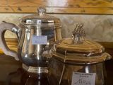 a silver tea pot and a silver teapot on a table