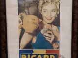 a framed picture of a woman holding a cup
