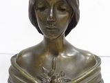 bronze bust of a woman with a flower in her hair