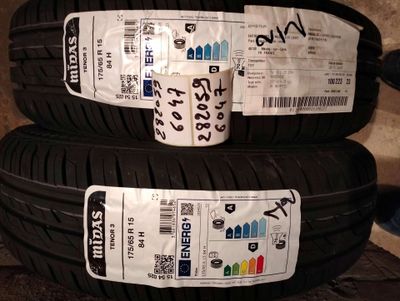 two tires with stickers on them are sitting on the ground